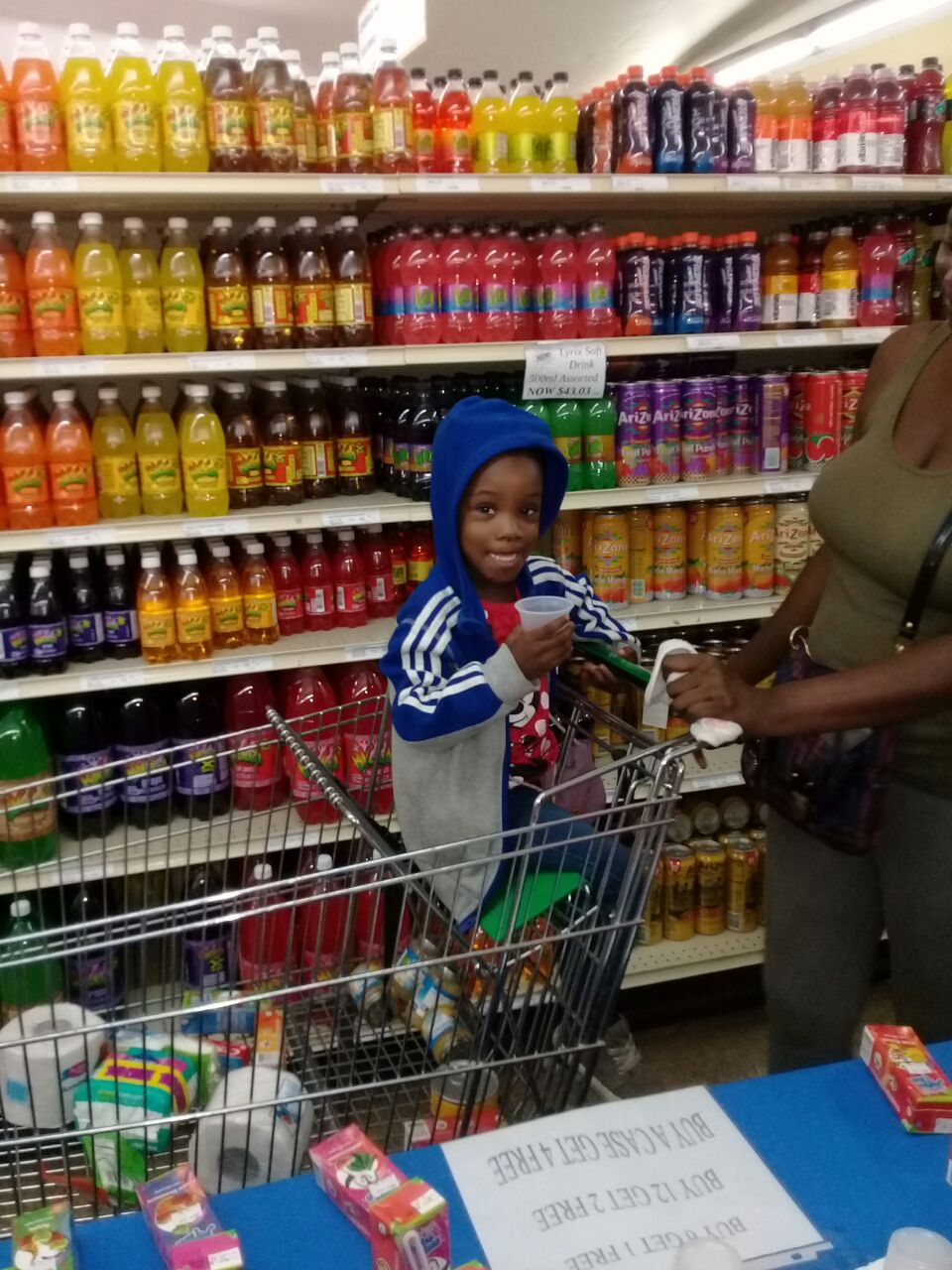 Little Girl in Cart Sampling Juice Time